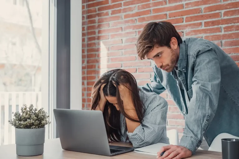 Entrepreneur frustré devant un ordinateur affichant des résultats e-commerce en baisse.